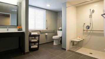 A modern bathroom with a shower, toilet, and sink.