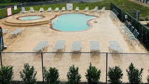 A swimming pool with multiple lanes and lounge chairs arranged around it. - Town Inn (Bordentown)