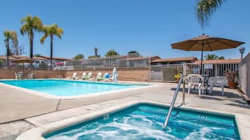 Una piscina al aire libre, sillones reclinables de piscina