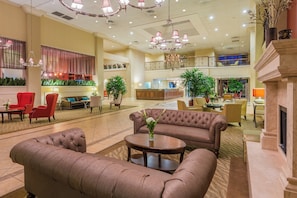 A spacious lobby with a grand chandelier, plush seating, and a reception desk. - Holiday Inn Mobile-Dwtn/Hist. District by IHG (Mobile)