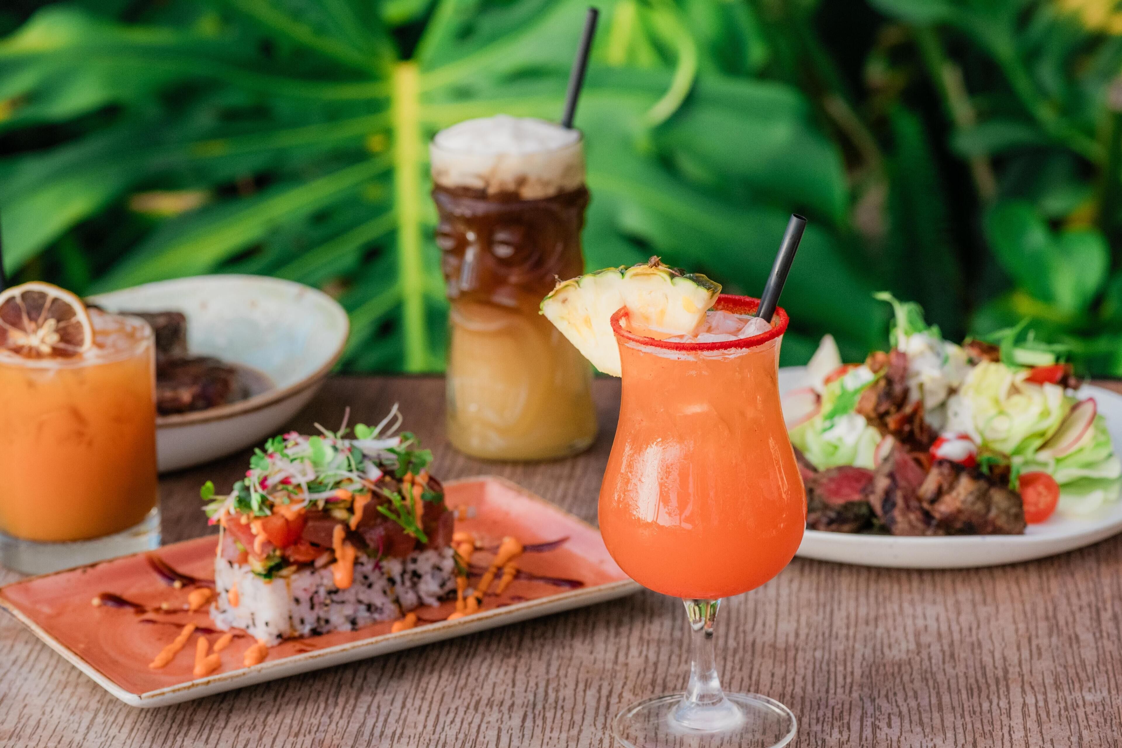 A table with a drink, a plate of sushi, and a salad.