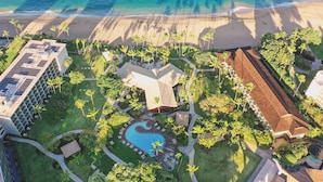 Luchtbeeld van een resort met een zwembad, palmbomen en een strand.