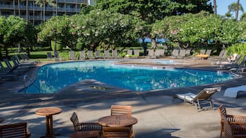 Una piscina al aire libre, sillones reclinables de piscina