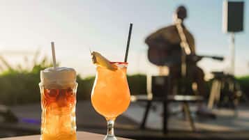 Two drinks on a table with a person in the background.