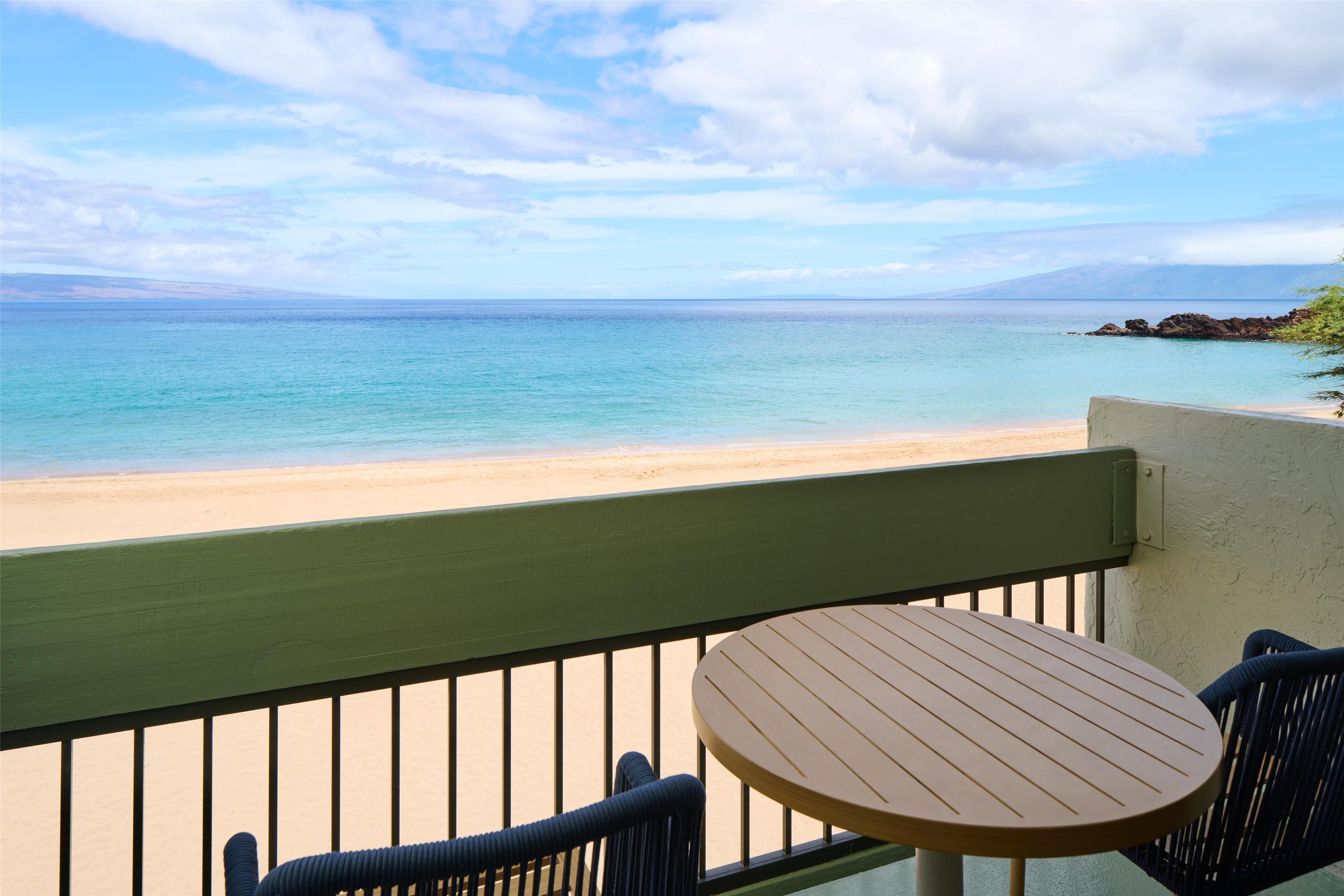 Un balcon avec vue sur une plage et l’océan.