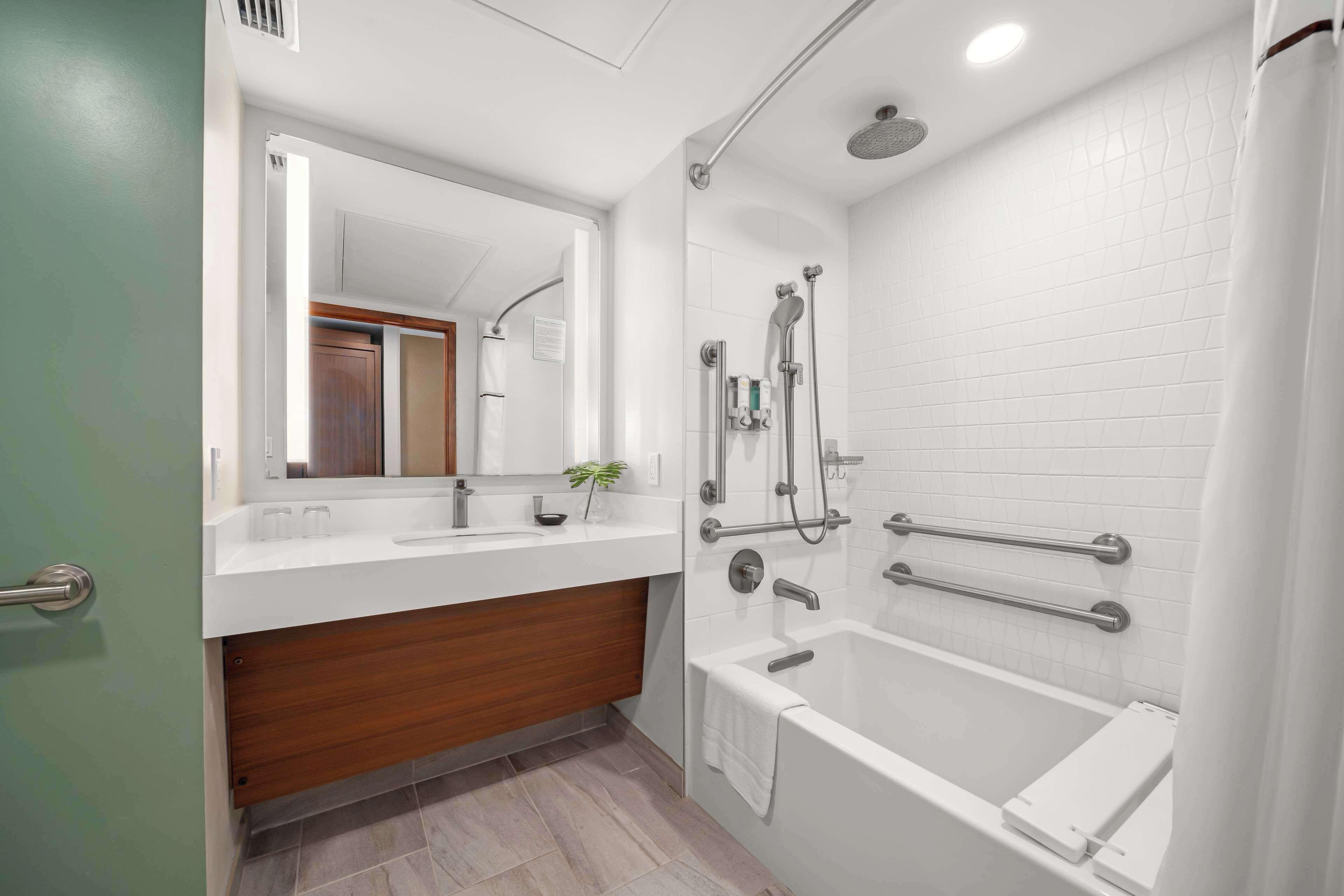 Une salle de bain moderne équipée d’une douche, d’une baignoire, d’un meuble-lavabo avec un miroir et d’un meuble en bois.