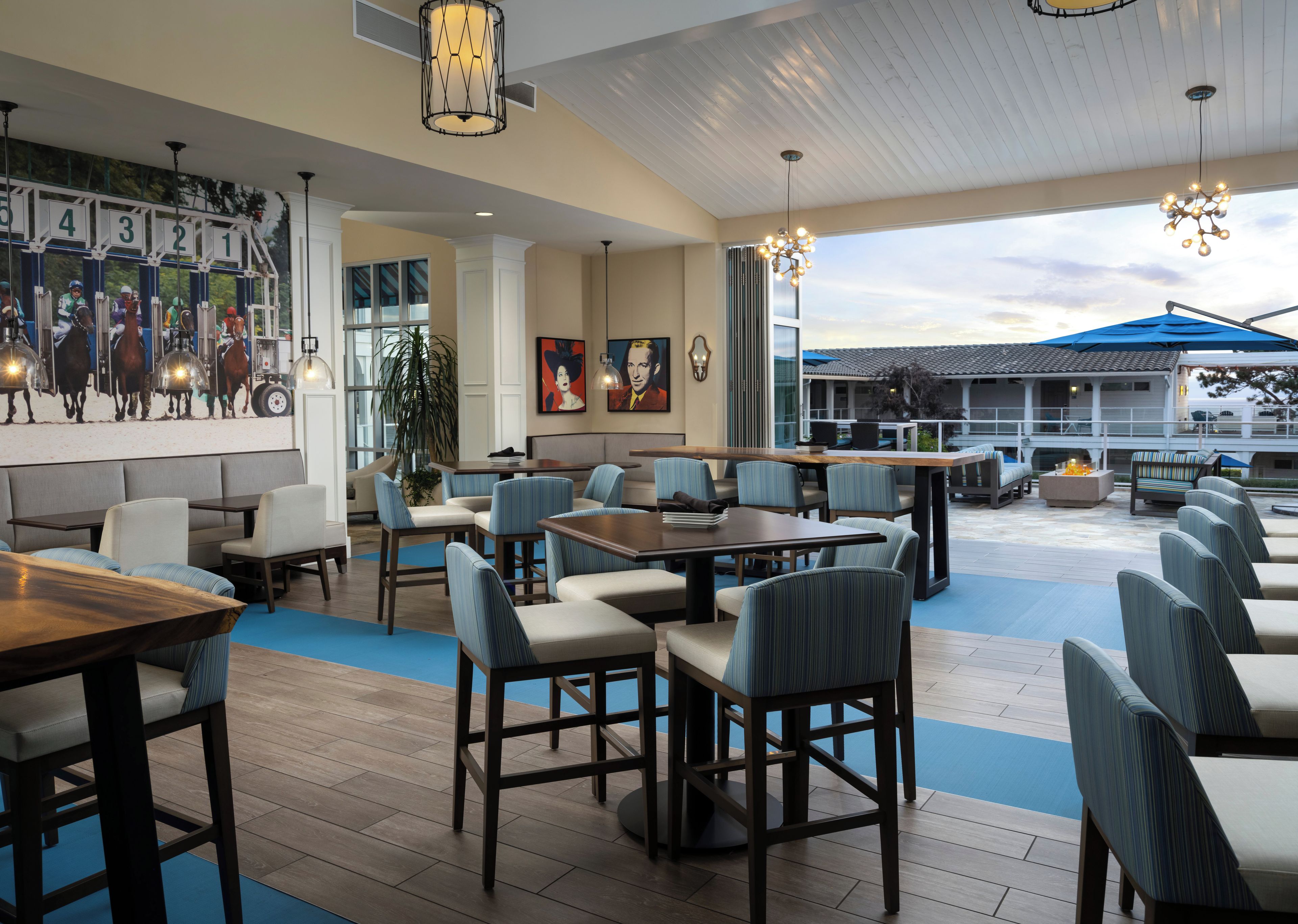 A restaurant with multiple seating areas, including booths and tables, and a large outdoor patio.