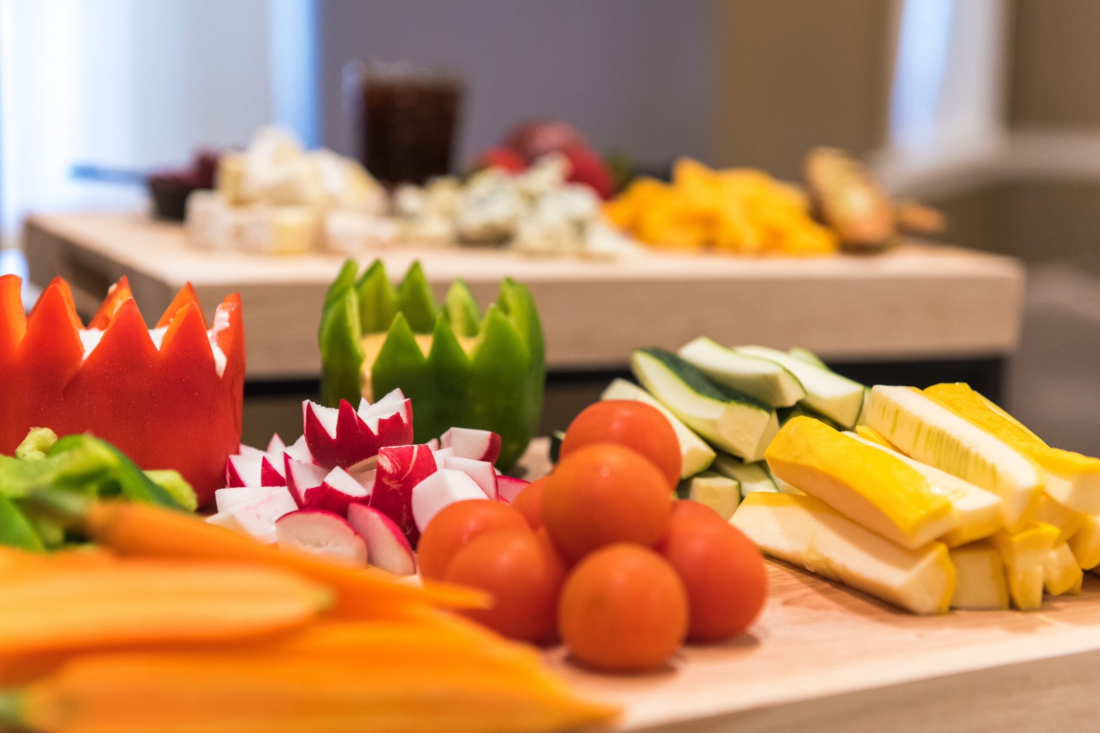 A variety of fresh vegetables and fruits on a wooden board.