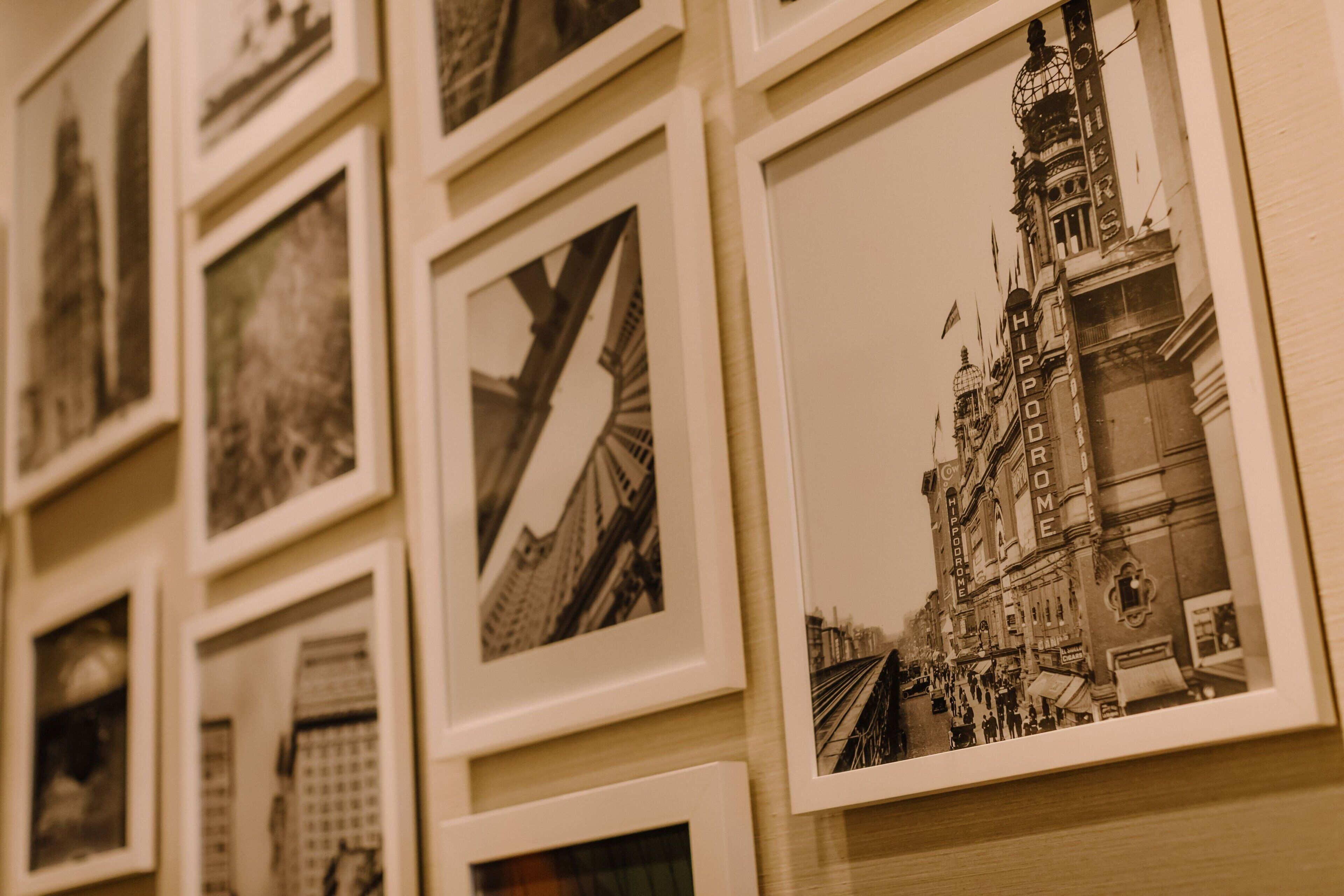 A wall of framed photographs depicting various architectural structures and cityscapes.