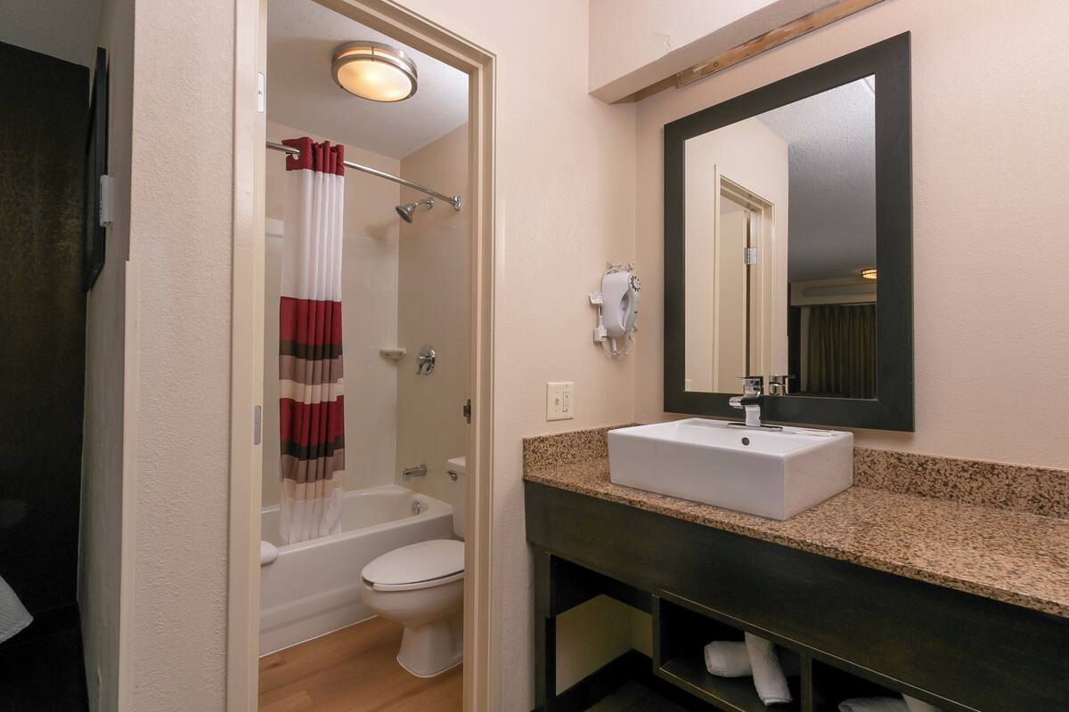 A bathroom with a bathtub, toilet, and sink.