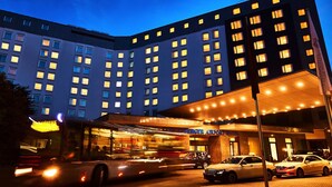 A hotel with a modern facade, multiple floors, and a well-lit entrance.