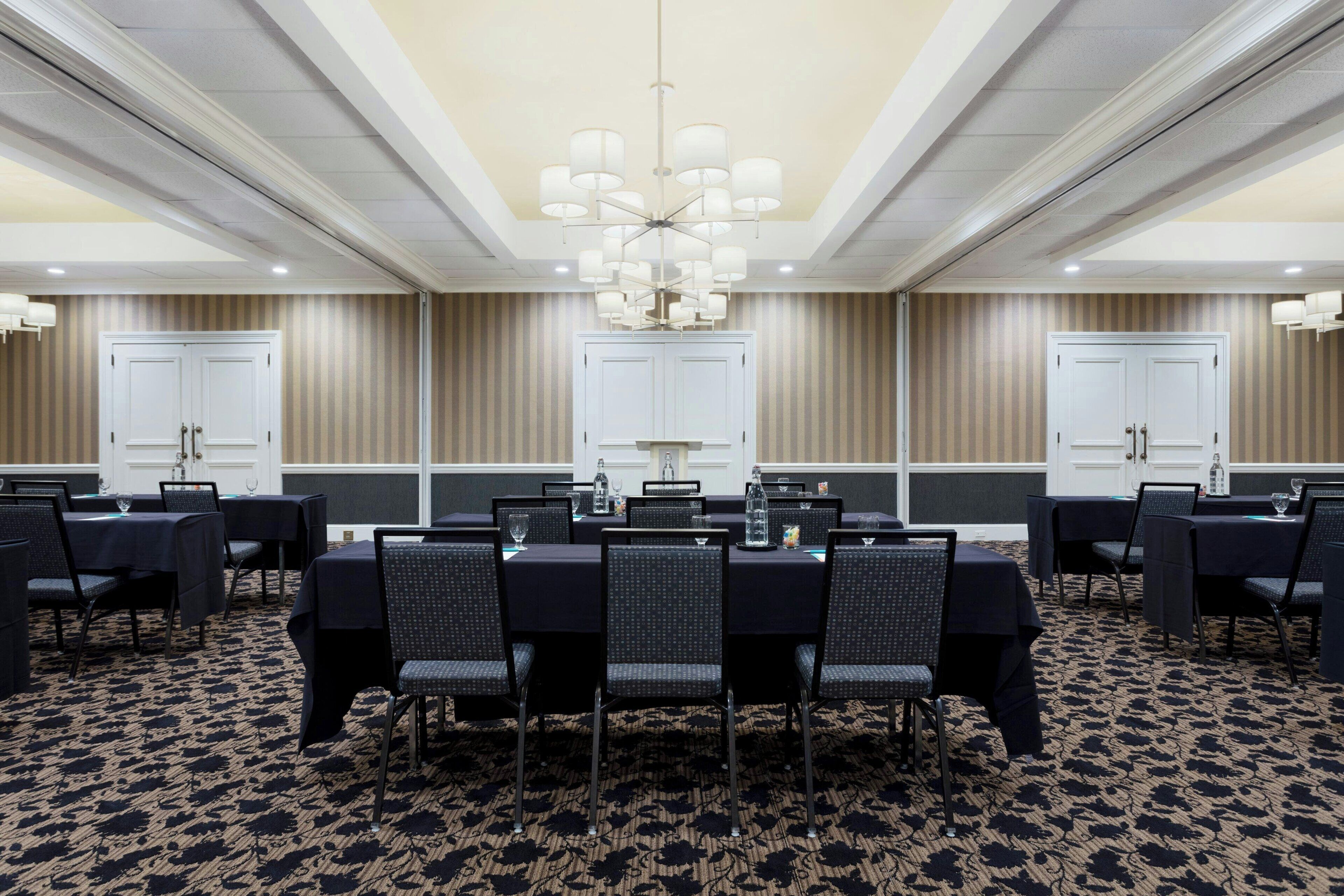 A conference room with a large table, chairs, and a chandelier.