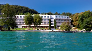Ein Hotel mit Namensschild, mehreren Stockwerken und Blick auf das Wasser.