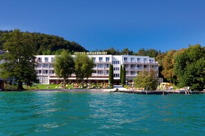 Un hôtel avec une enseigne, plusieurs étages et une vue sur le front de mer.