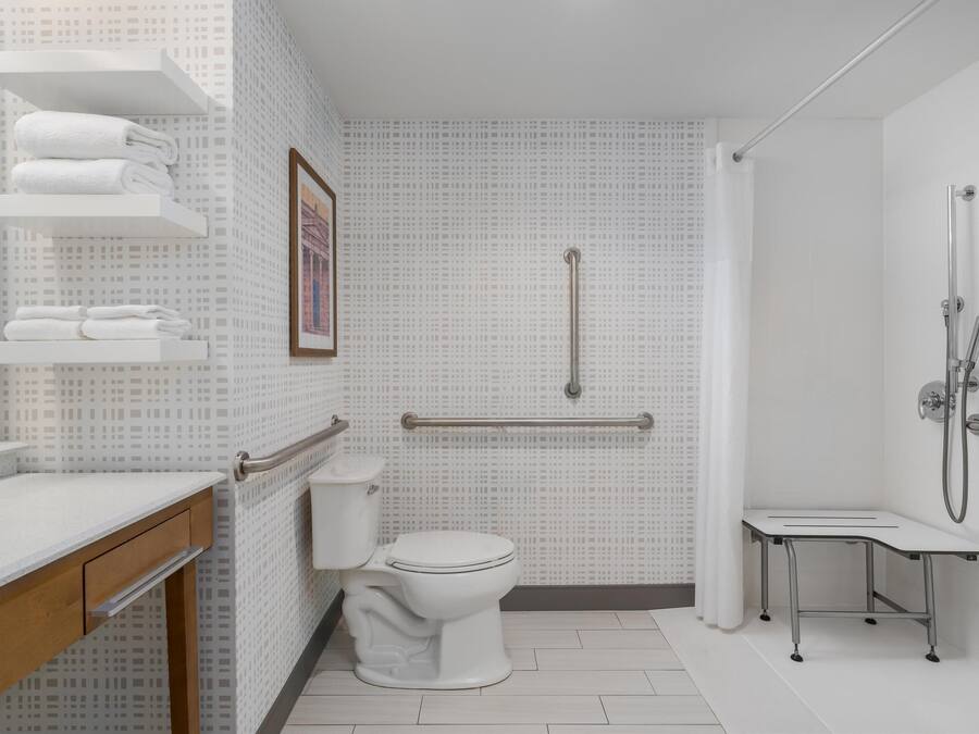 Une salle de bain moderne équipée de toilettes, d’une douche et d’un meuble-lavabo avec un miroir.