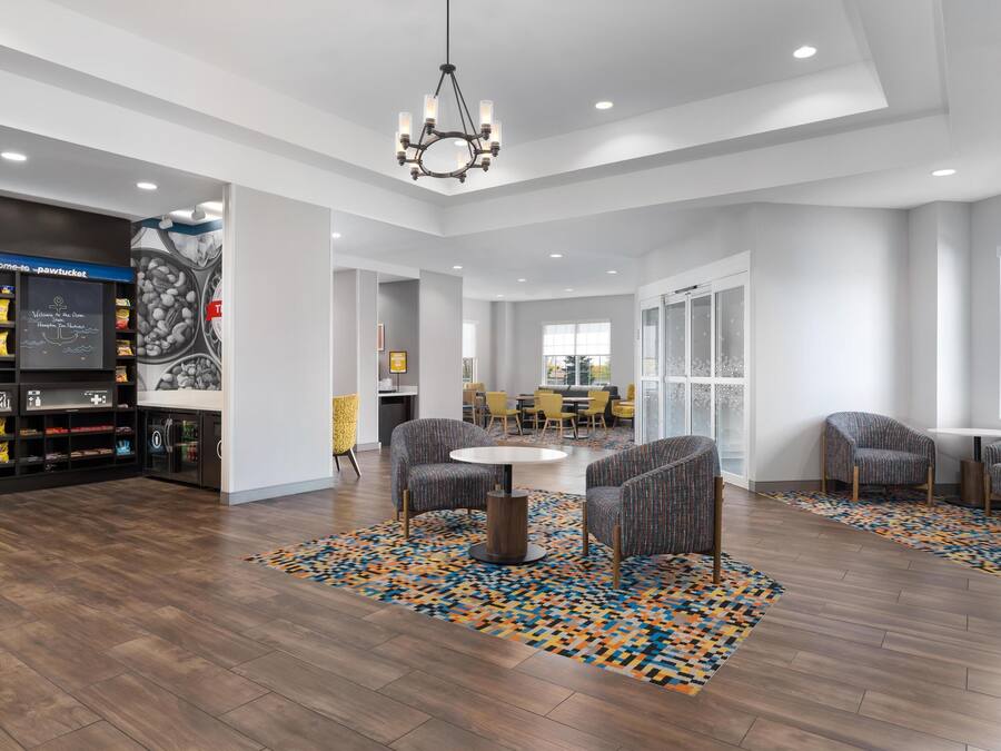 A modern lobby with a coffee station, seating area, and a large window.