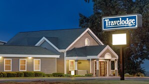 Un hotel Travelodge con una fachada bien iluminada, un letrero llamativo y un estilo arquitectónico tradicional.