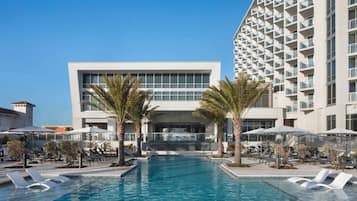 Alberca techada, alberca al aire libre y sombrillas en la alberca