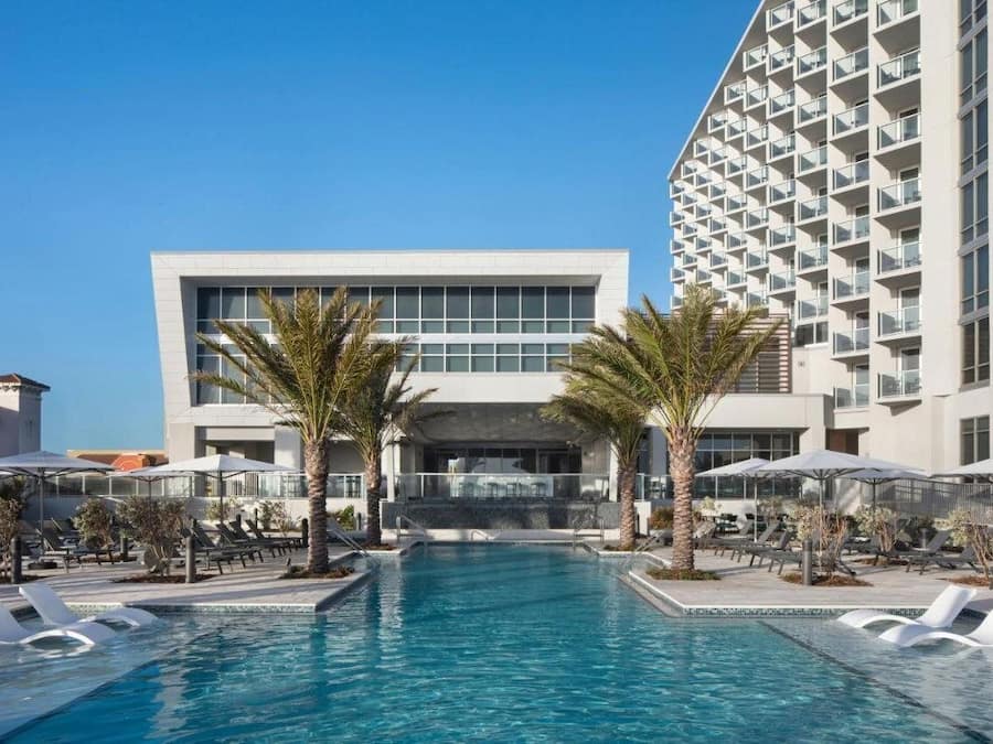 Alberca techada, alberca al aire libre y sombrillas en la alberca