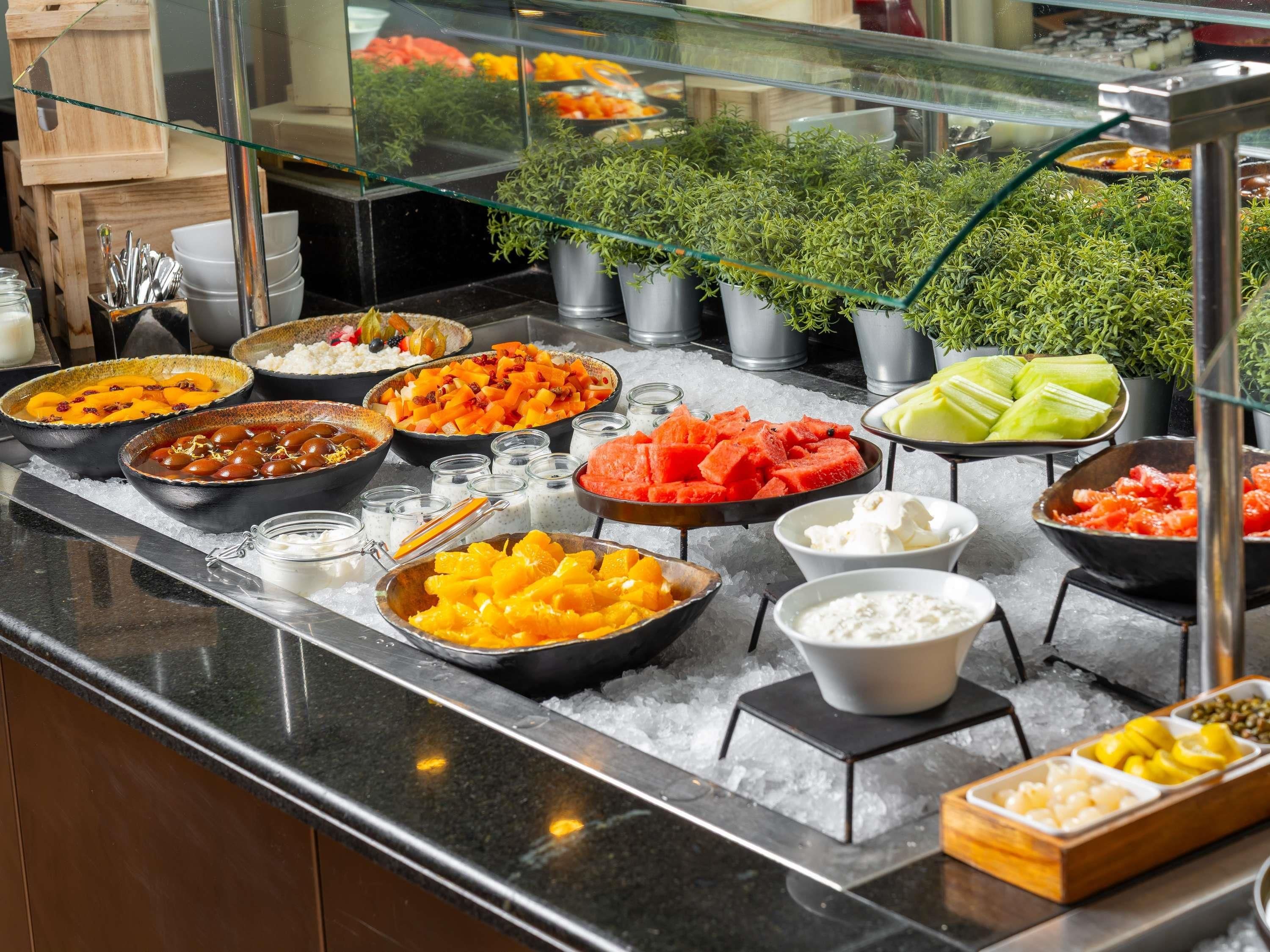 A buffet with various food items and a glass display case.
