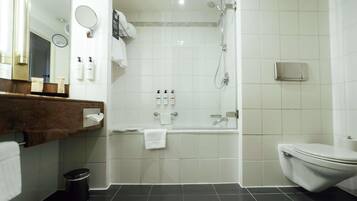 A modern bathroom with a bathtub, toilet, and shower.