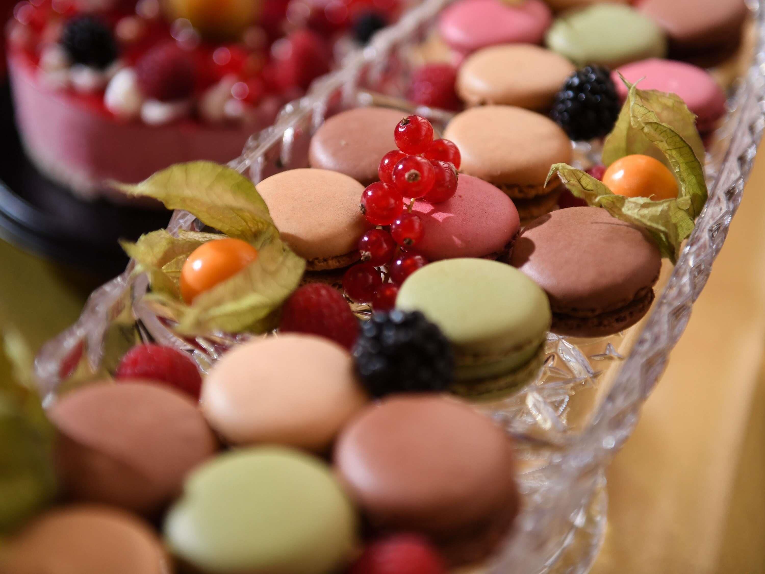 A tray of assorted macarons and berries.