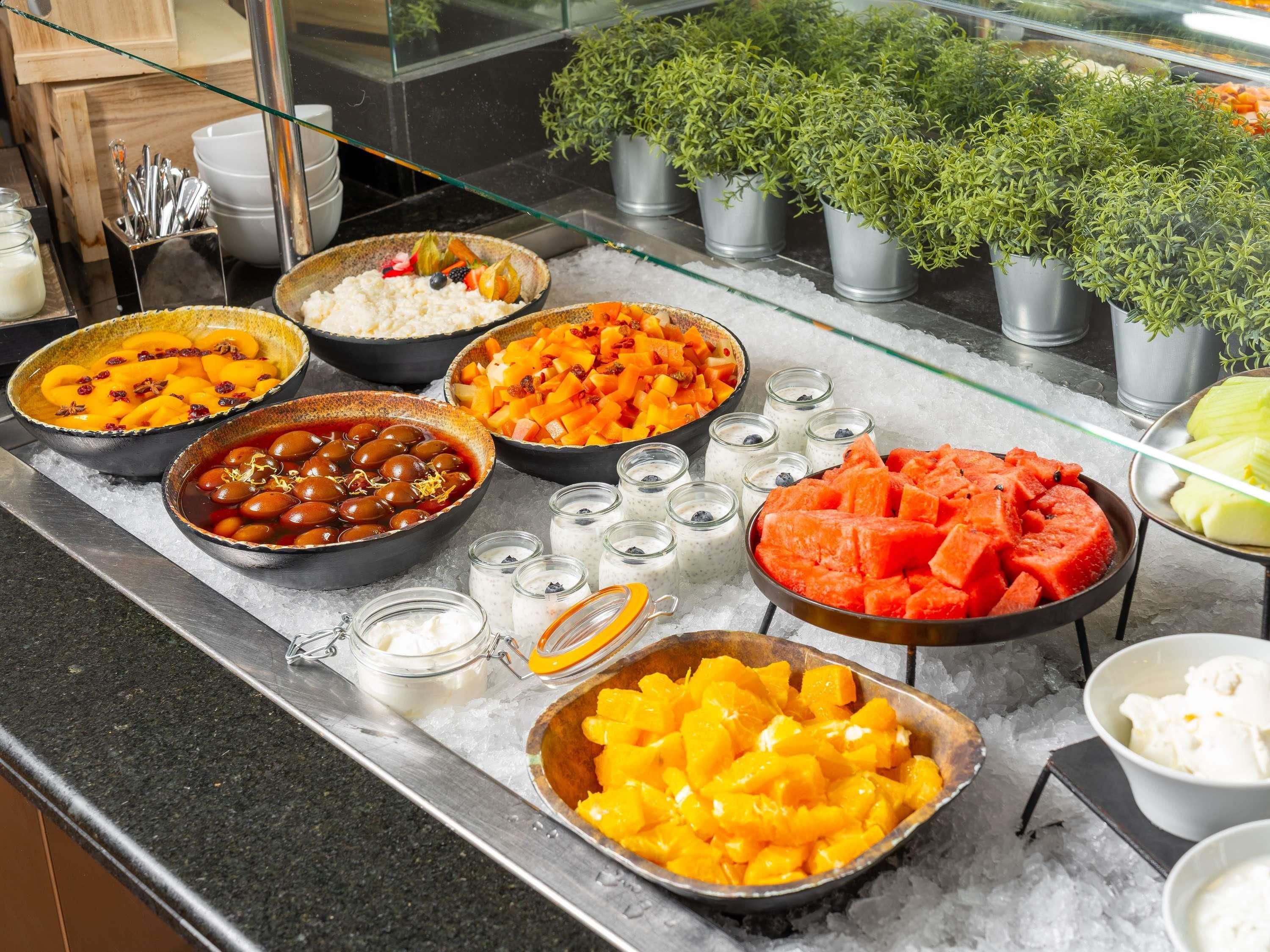 A buffet with various food items including fruits, vegetables, and desserts.