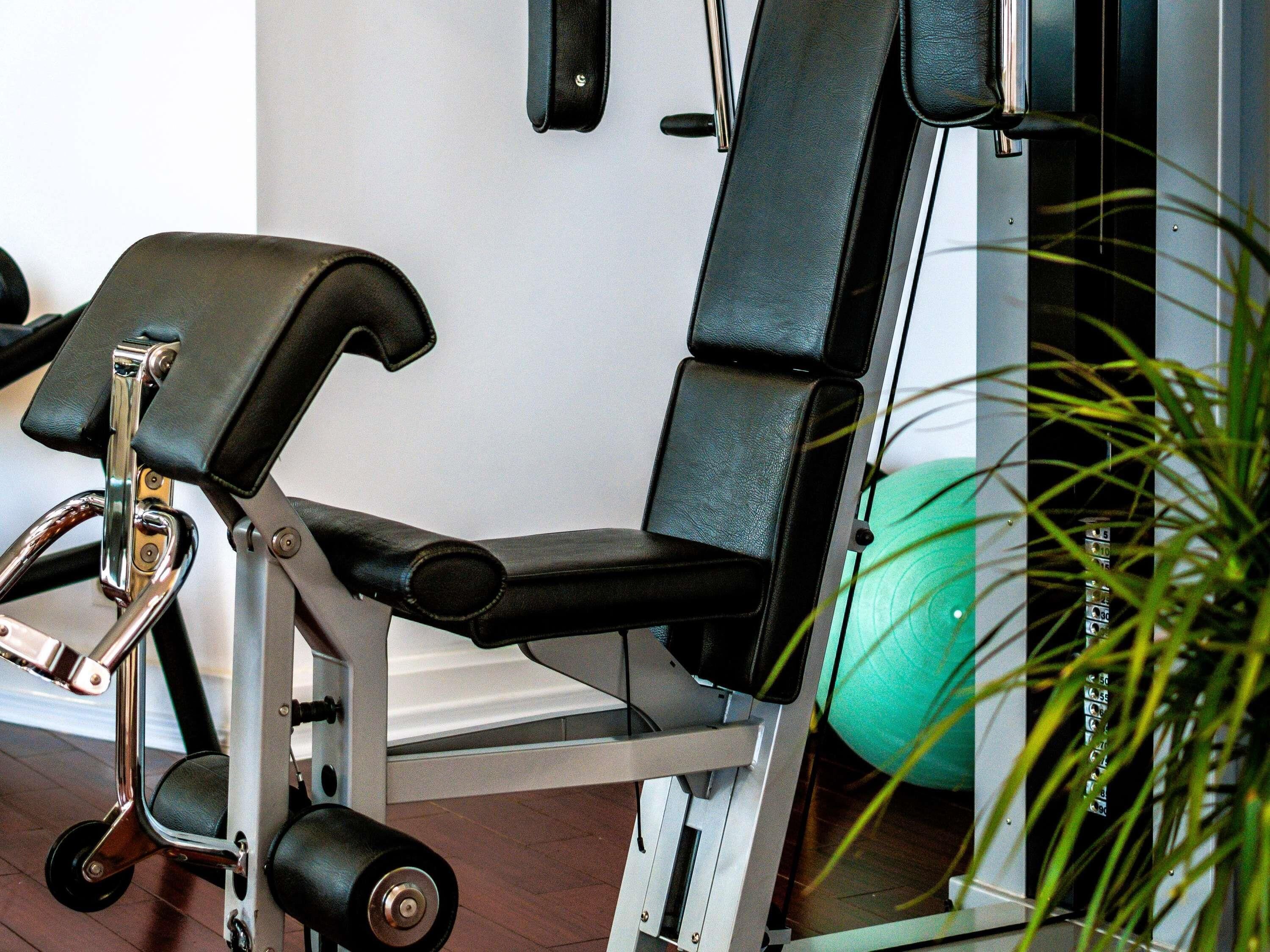 Ett gym med träningsutrustning, inklusive en bänk och vikter.