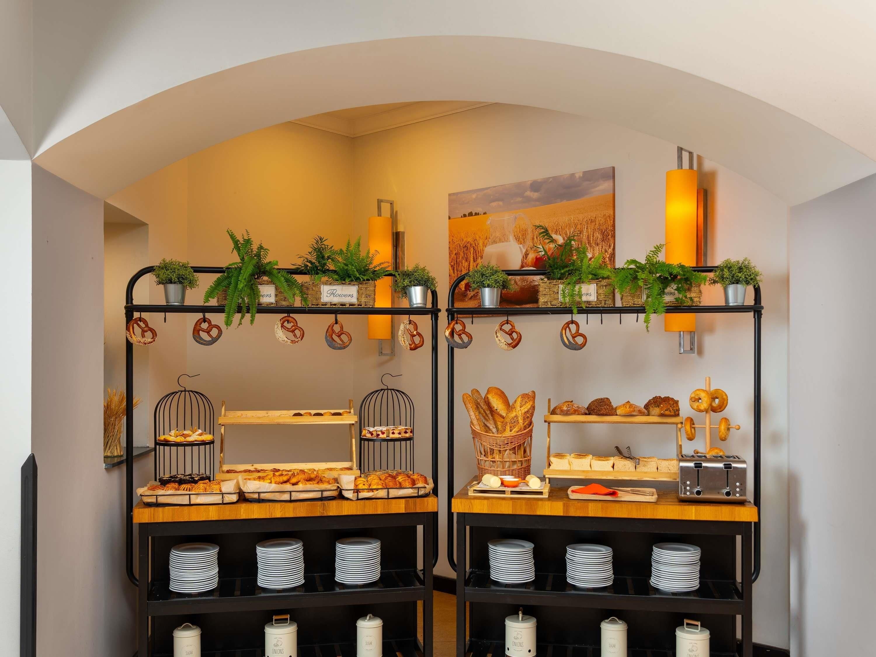 Ein reichhaltiges Frühstücksbuffet mit verschiedenen Speisen und einer dekorativen Pflanzengestaltung.