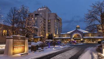 A Delta Hotel with a snow-covered entrance and illuminated sign.