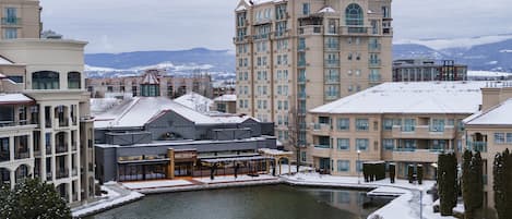 A hotel with a central courtyard, multiple balconies, and a view of snow-covered mountains.