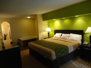 Relax in comfort with a large bed, two nightstands, and a small table, set against a unique accent wall.