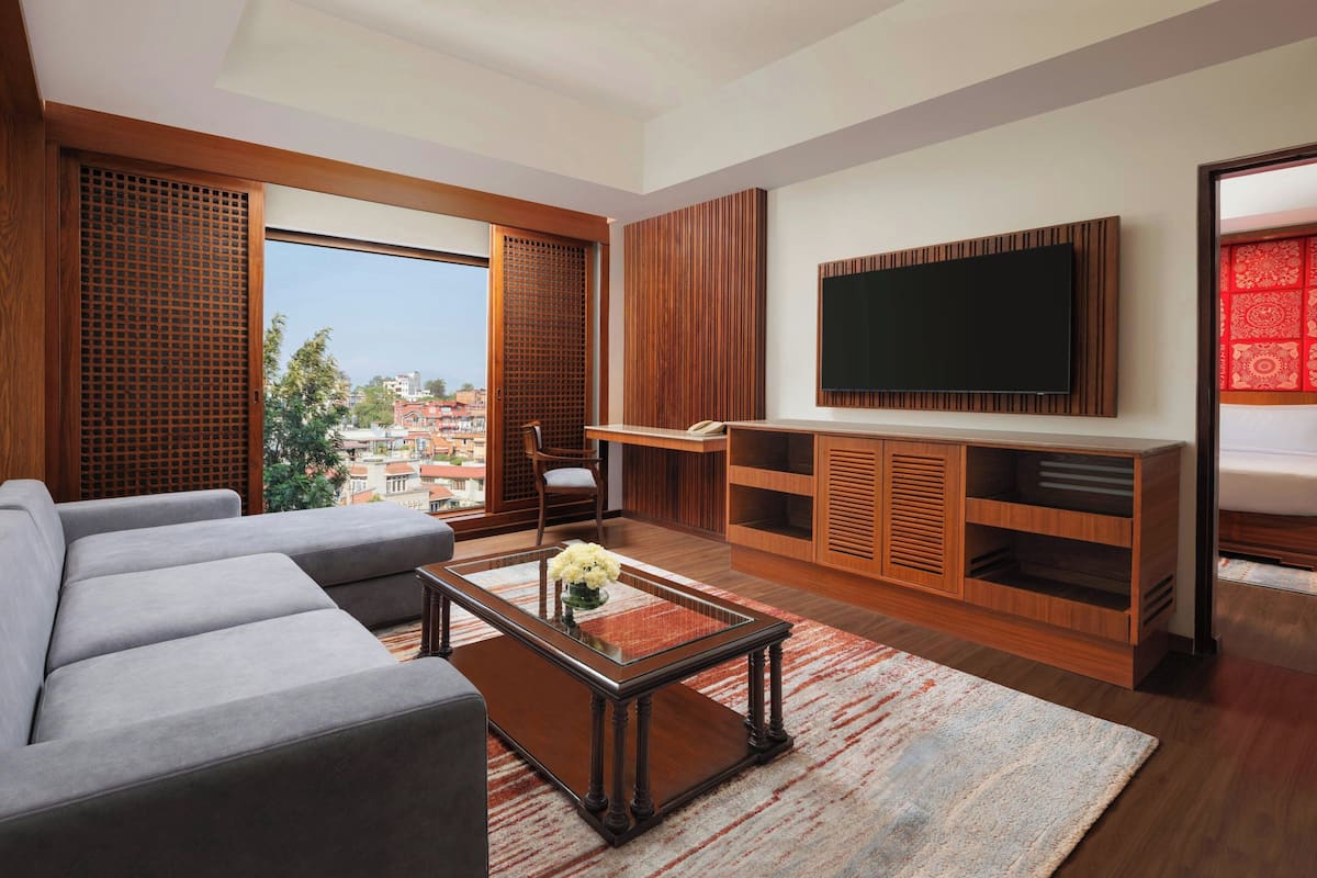 A modern living room with a sofa, coffee table, TV, and wooden paneling.