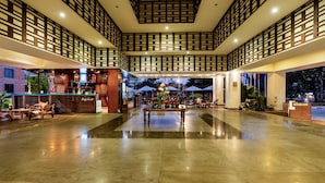 A spacious lobby with a polished marble floor, a reception desk, and a seating area with a bench.