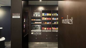 A vending machine area with snacks and a microwave.