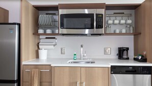 Una cocina moderna con un refrigerador de acero inoxidable, un microondas y un lavavajillas.