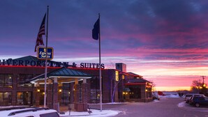 Un bâtiment en briques sur lequel on peut lire l’inscription « Riverport Inn & Suites », et deux drapeaux.