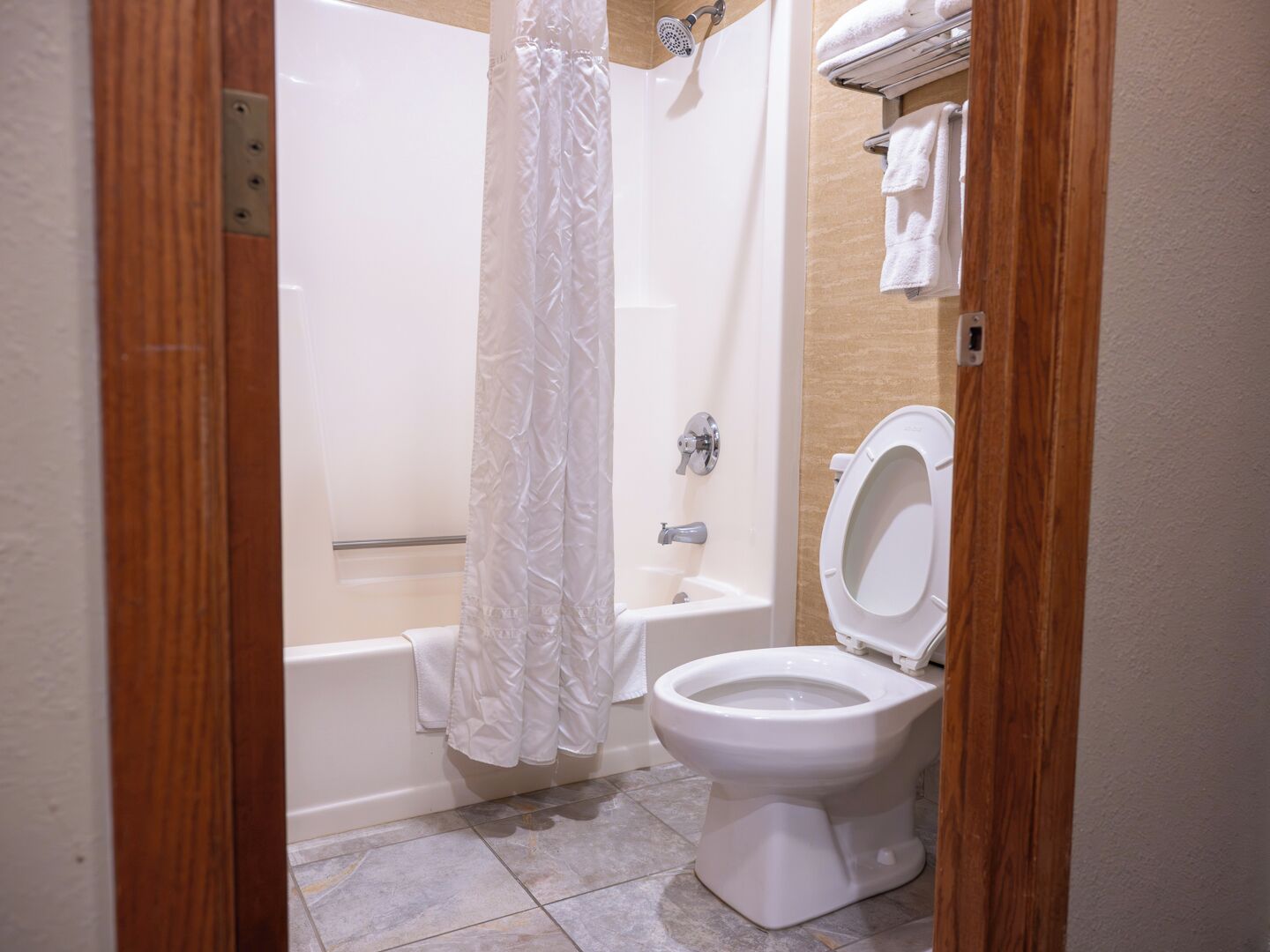 Un baño con bañera, inodoro y cortina de ducha.