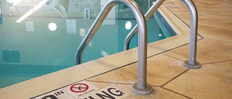 A pool area with metal handrails and a 'No Diving' sign.