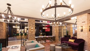 A spacious lobby with a bar area, seating arrangements, and a chandelier. - Westgate New York Grand Central (New York)