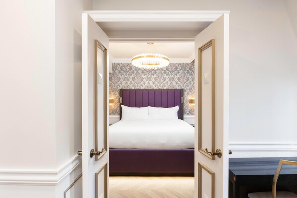 A bedroom with a large bed, a purple headboard, and a chandelier. - Westgate New York Grand Central (New York)