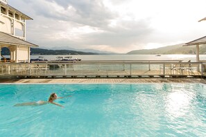 Una piscina cubierta, una piscina al aire libre, sombrillas, tumbonas