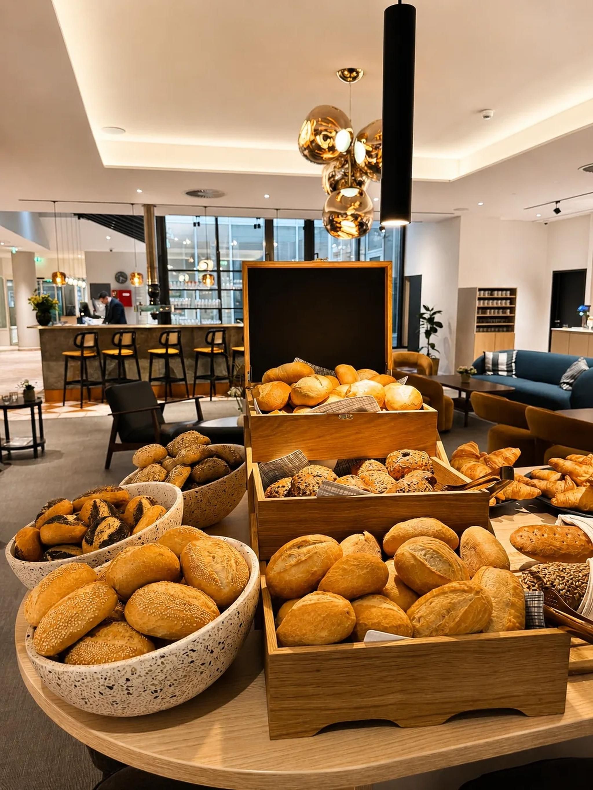 Um interior moderno com uma vitrine de padaria exibindo diversos pães e doces.