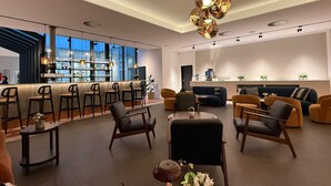 Un intérieur moderne avec un bar, des sièges et un luminaire décoratif au plafond.