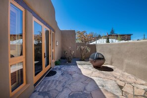 A modern house with a stone patio, large windows, and a barbecue grill. - La Posada de Santa Fe, A Tribute Portfolio Resort & Spa by Marriott (Santa Fe)