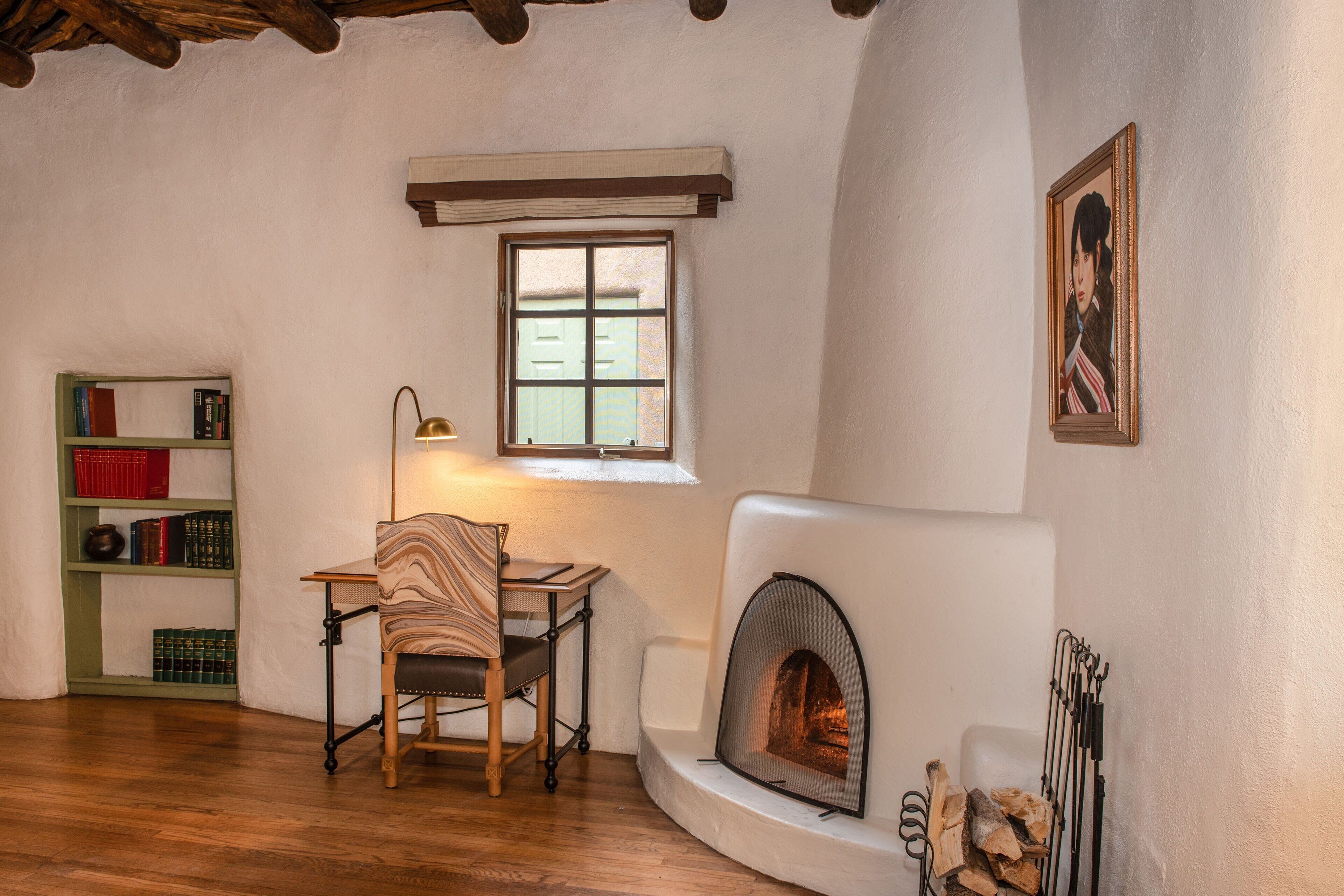 Una habitación acogedora con chimenea, una estantería y una silla.