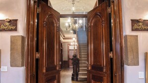 A wooden staircase with a chandelier, leading to a room with a sign reading "The Stab House". - La Posada de Santa Fe, A Tribute Portfolio Resort & Spa by Marriott (Santa Fe)