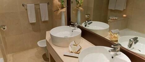 A modern bathroom with two sinks, a large mirror, and a toilet.