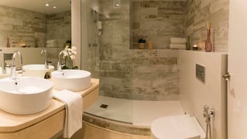 Ein modernes Badezimmer mit zwei Waschbecken, einer gläsernen Dusche und einer Toilette.
