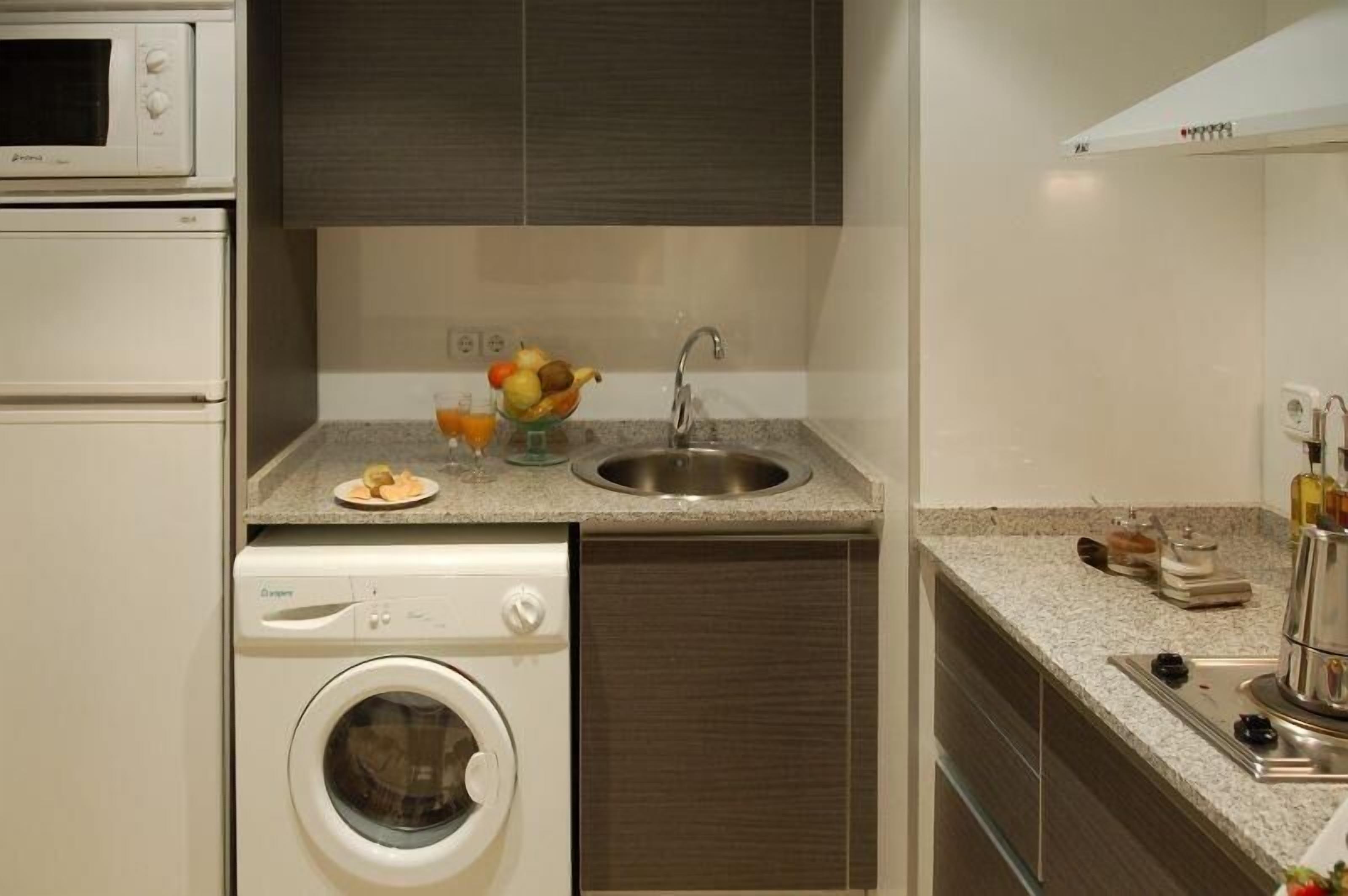 Una cocina compacta con horno integrado, microondas y lavavajillas.